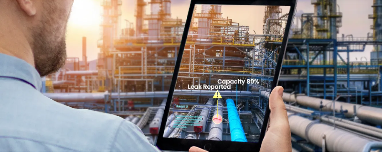 a man holding a tablet with a view of an oil refinery